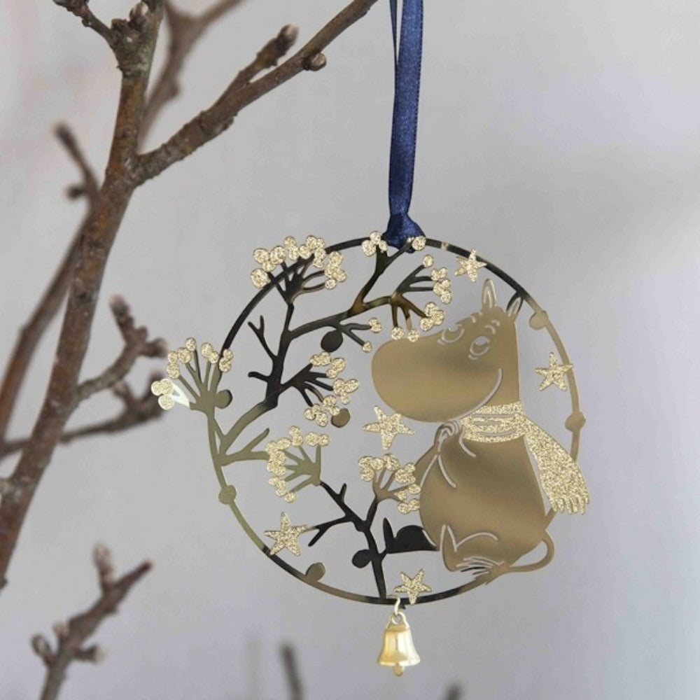 aelgmark gold Moomin Christmas ornament with glittery scarf and bell, hanging on a branch.
