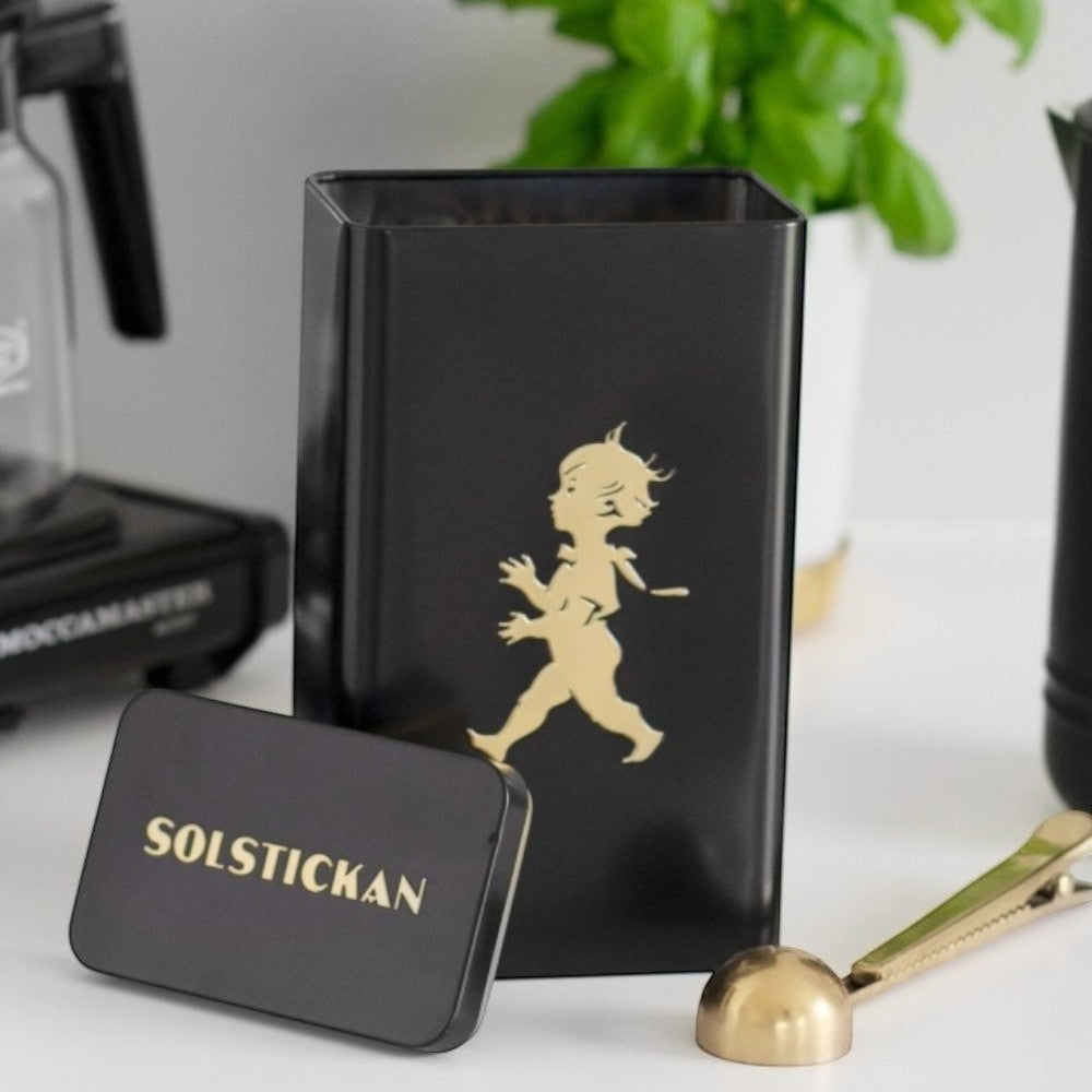 Solstickan black tin with gold boy graphic, perfect for storing coffee bags.