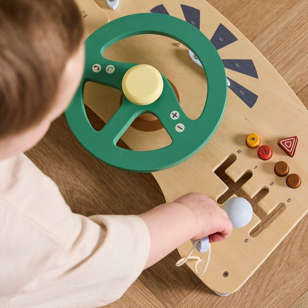 aelgmark 北歐生活選物 Kid’s Concept 木製汽車駕駛遊戲板，孩子正在操作綠色方向盤與排檔桿，訓練手眼協調。
