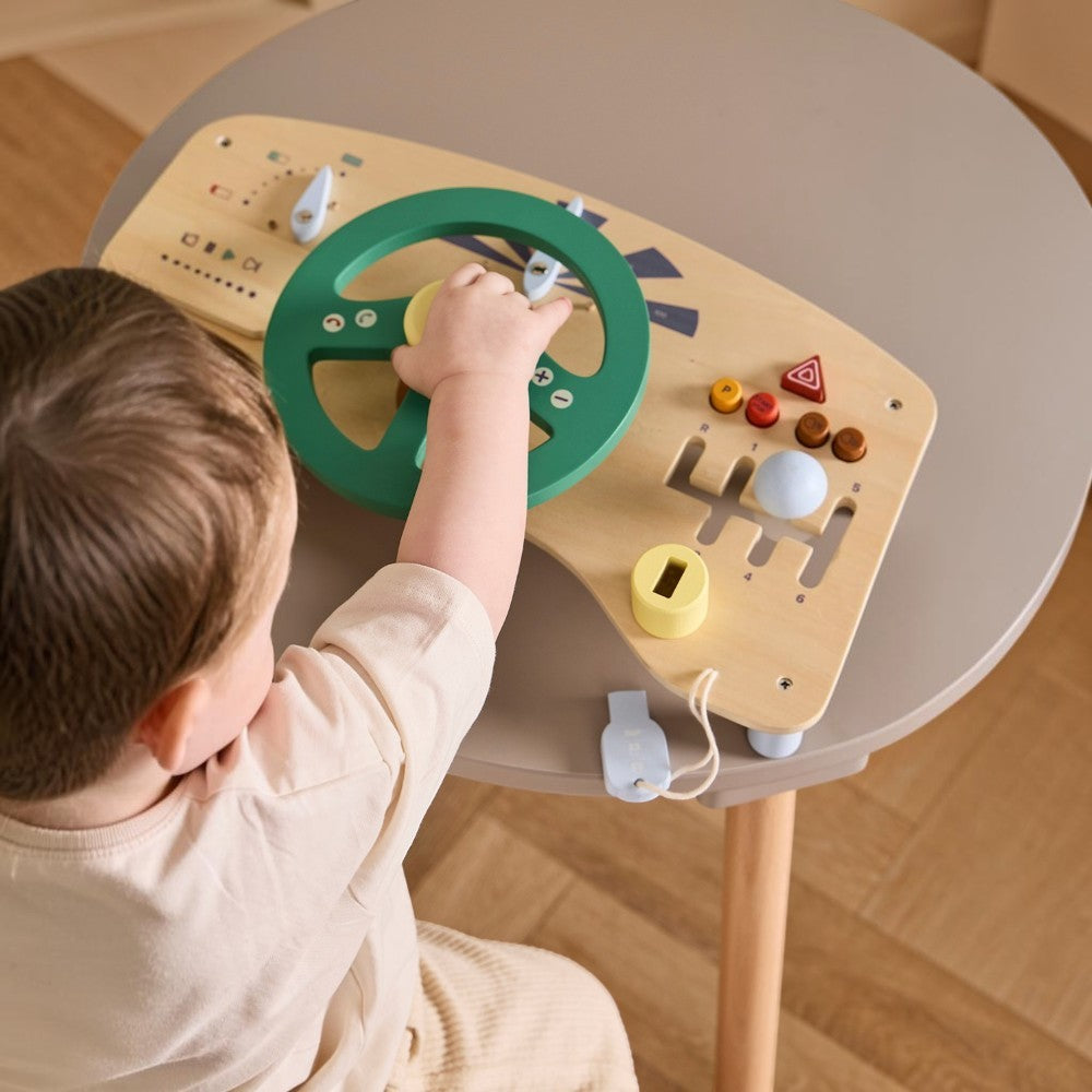 aelgmark 北歐生活選物 Kid’s Concept 木製汽車駕駛遊戲板，孩子正在操作綠色方向盤與排檔，培養手眼協調。