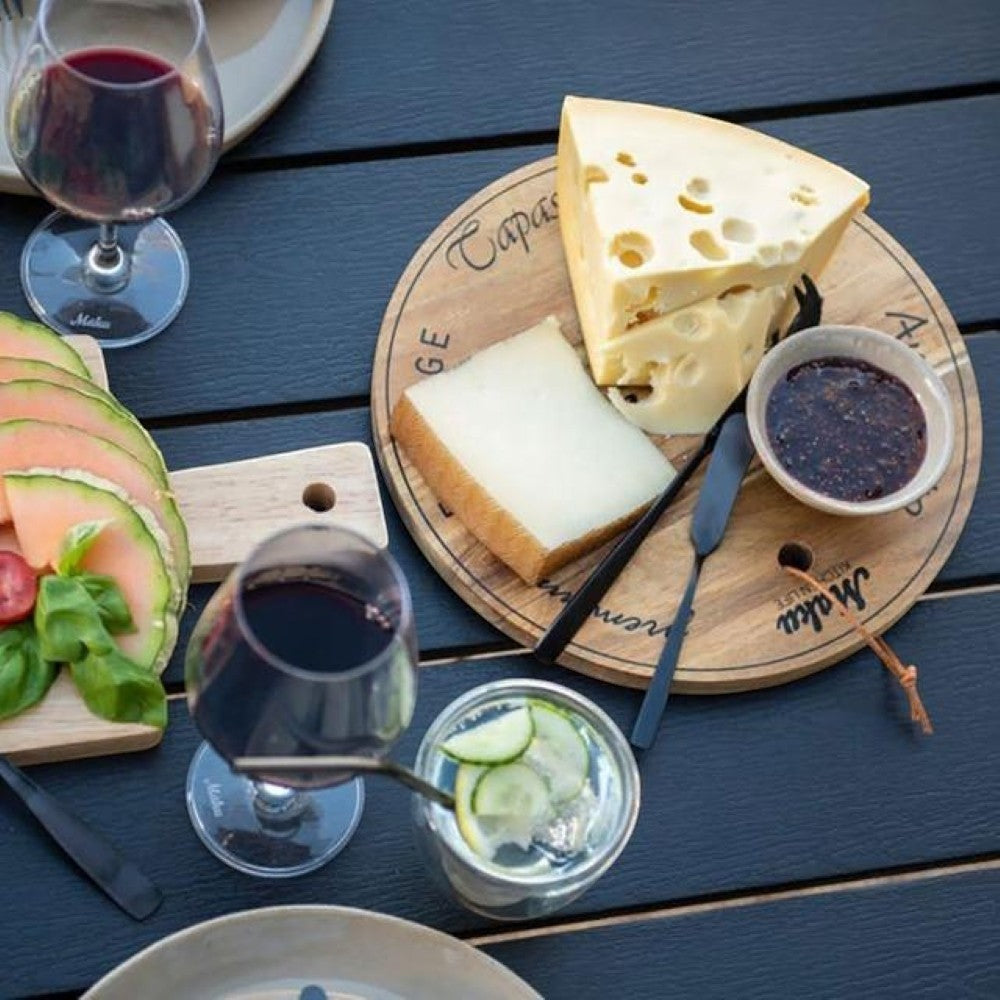 aelgmark acacia wood round cheese board with cheese, jam, and knives. Perfect for appetizers or desserts.