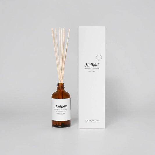aelgmark Alpine Tundra room diffuser in amber glass bottle with natural reeds. Scent notes of juniper and rosemary.