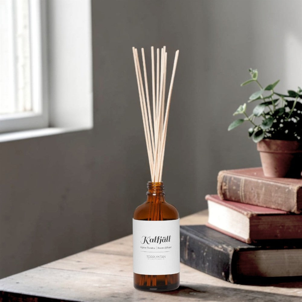 aelgmark Alpine Tundra room diffuser in amber glass bottle with reeds. Scent notes: juniper and rosemary.