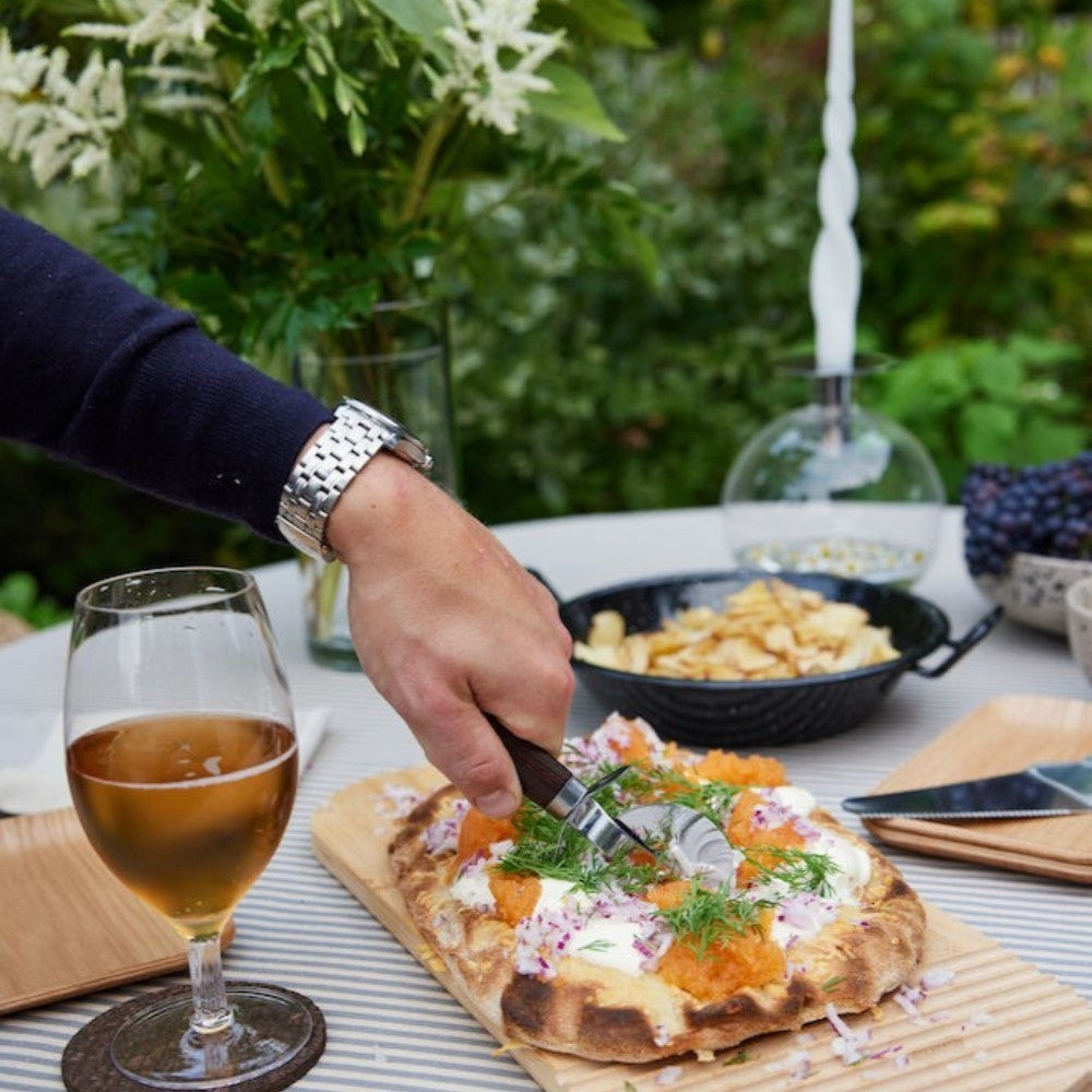 aelgmark Astrid stainless steel pizza cutter with chocolate brown wood handle, perfect for pizzas and pies.