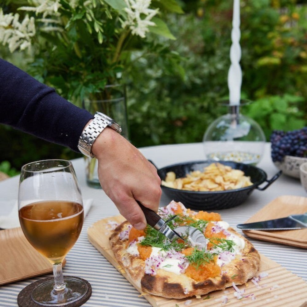 aelgmark Astrid stainless steel pizza cutter with chocolate brown wood handle, perfect for pizzas and pies.
