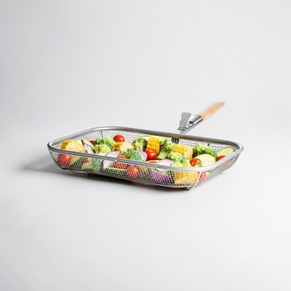Aelgmark Fredde BBQ grill basket with removable wooden handle, filled with corn, broccoli, tomatoes, and red onion.