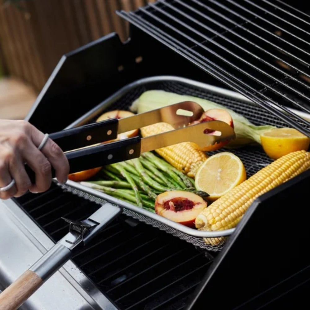 aelgmark Fredde BBQ grilling basket with corn, asparagus, peaches, and lemon. Detachable wooden handle for easy use.