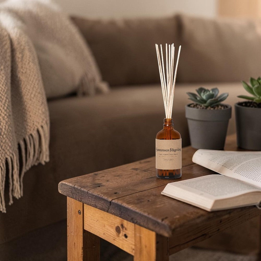 aelgmark Beauty of Summer room diffuser in amber glass bottle with natural reeds, featuring a kraft paper label with Swedish text.