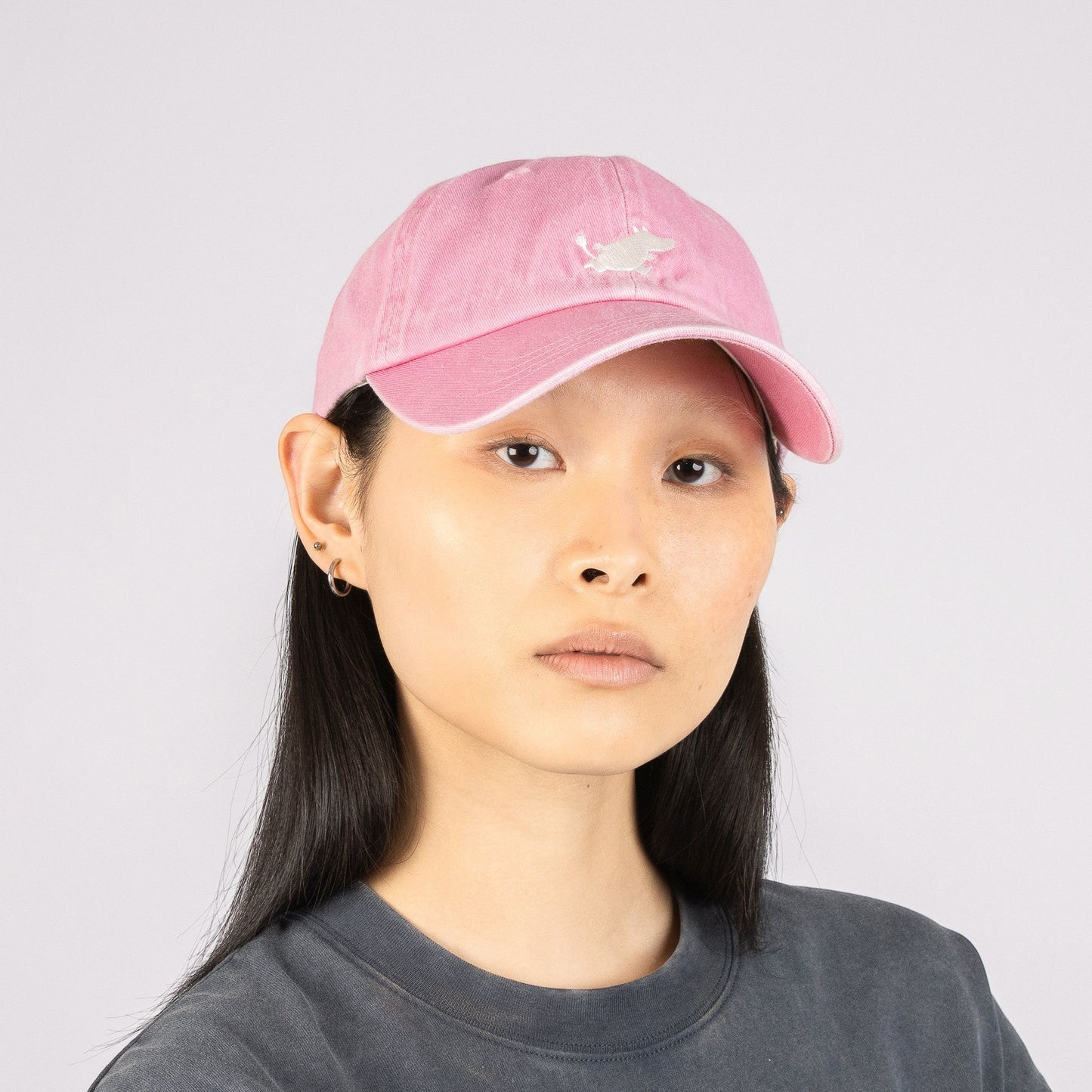 aelgmark 北歐生活選物粉色姆明刺繡純棉老帽，模特兒配戴展示經典丹寧風格與簡約設計