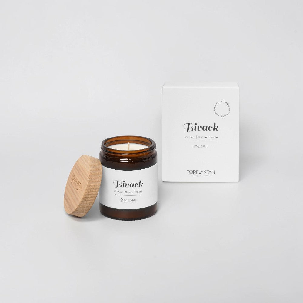 aelgmark Bivack scented candle in amber glass jar with wooden lid, notes of cinnamon and blackberry.