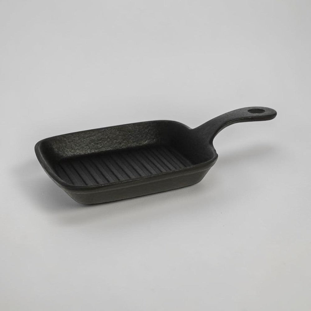 aelgmark black cast iron single-serving grill pan with ridged surface and handle.