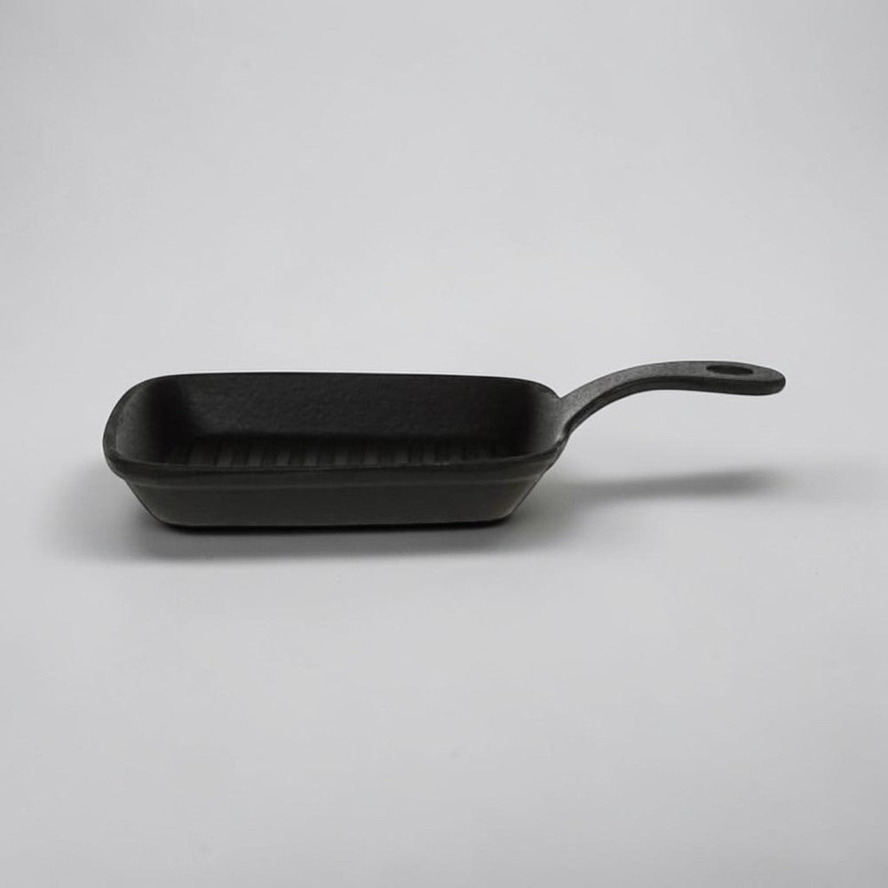 aelgmark matte black cast iron single-serving grill pan with ridged surface and handle.