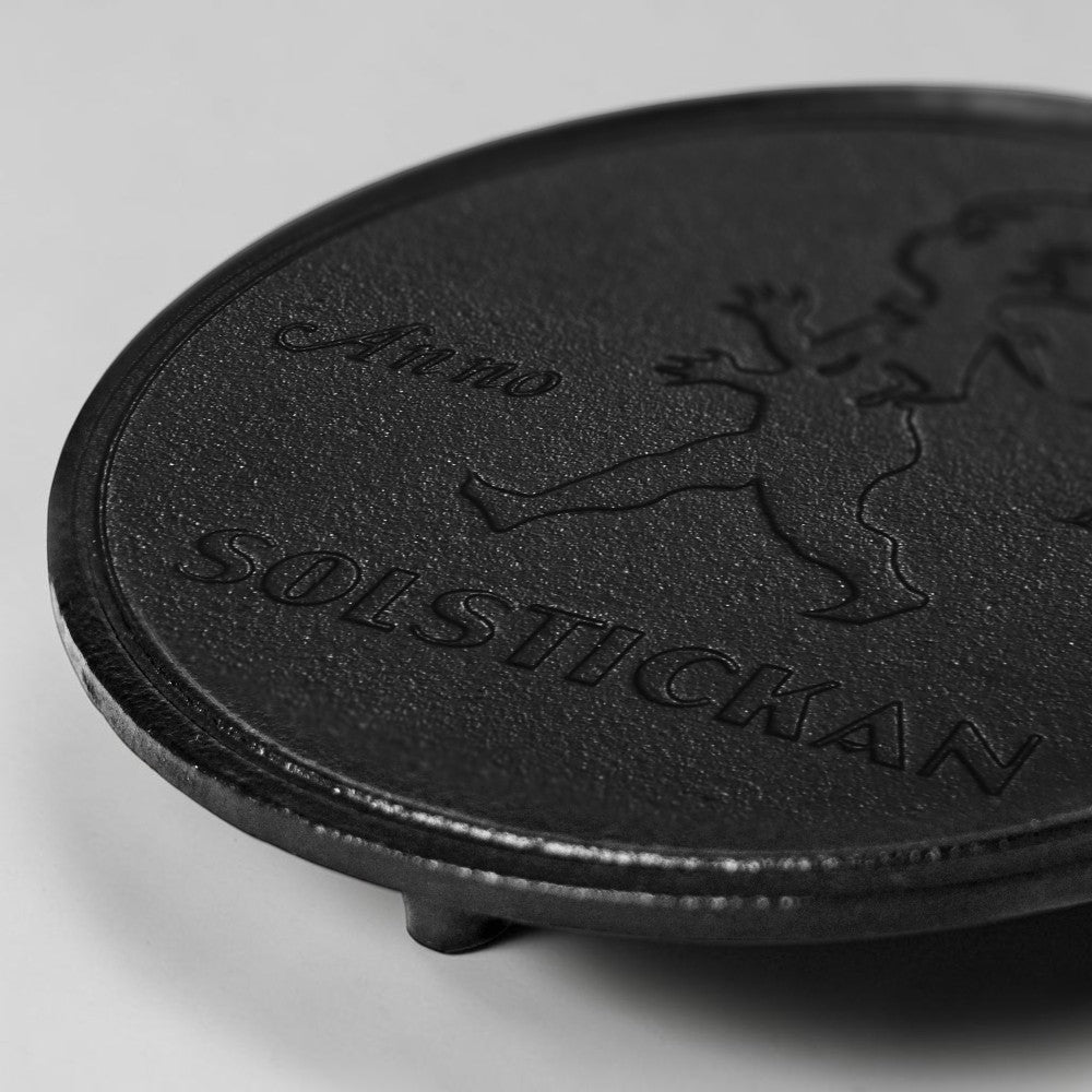 aelgmark black cast iron trivet with embossed SOLSTICKAN logo and boy graphic