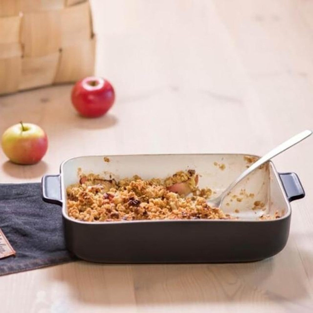 aelgmark black ceramic baking dish with apple crumble and a spoon, perfect for desserts and baking.