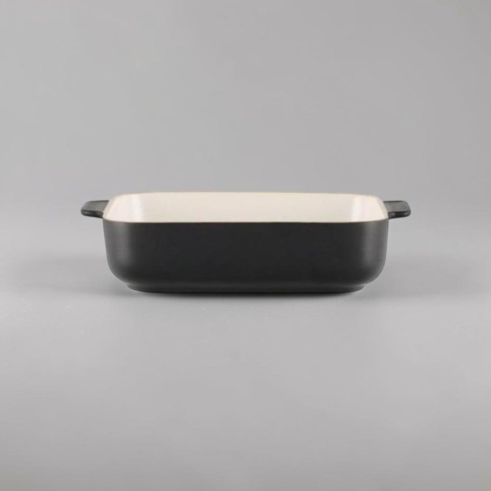 Aelgmark black ceramic baking dish with cream interior and side handles. Rectangular shape, ideal for oven use.