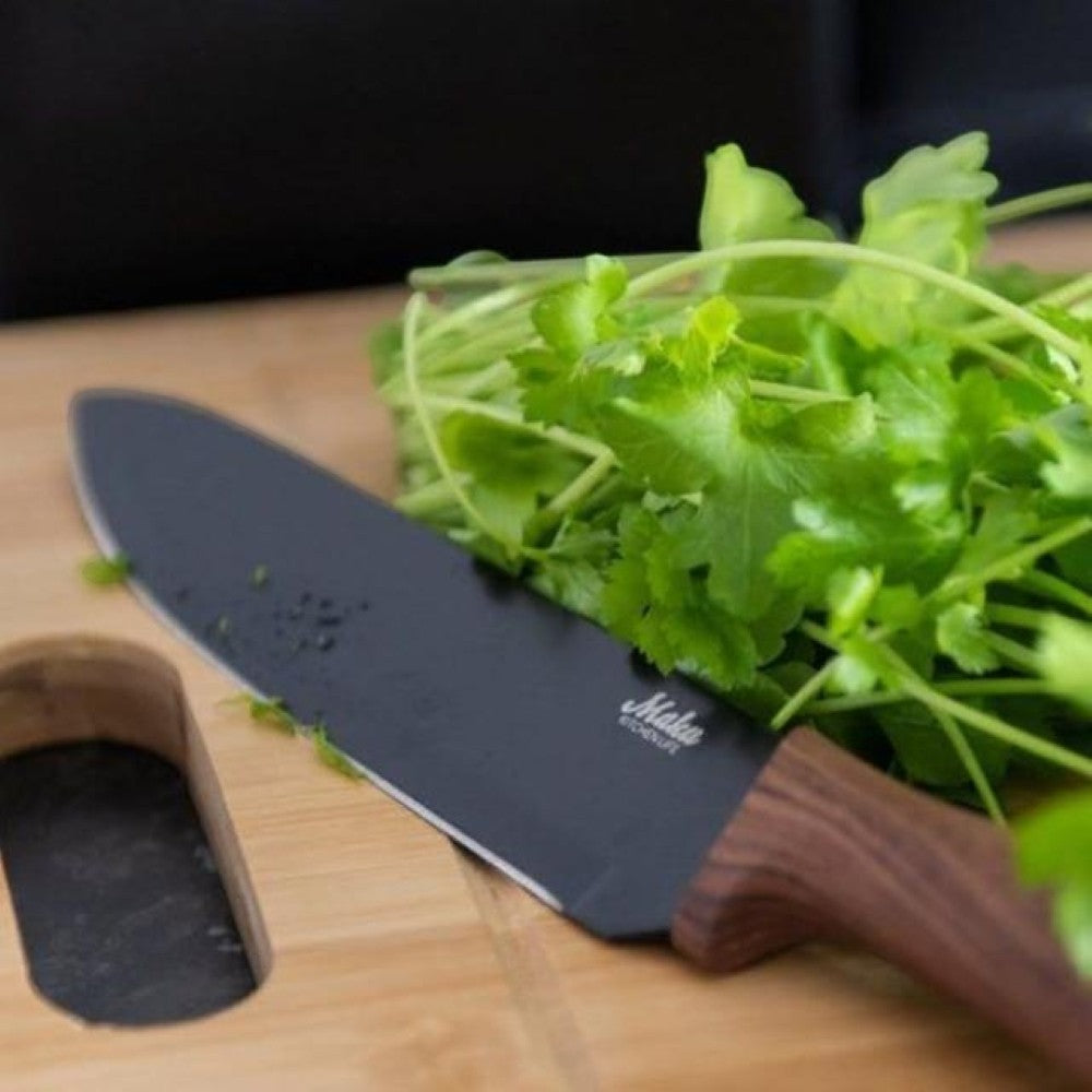 aelgmark chef's knife with black stainless steel blade and wood-look TPR handle, next to fresh cilantro.
