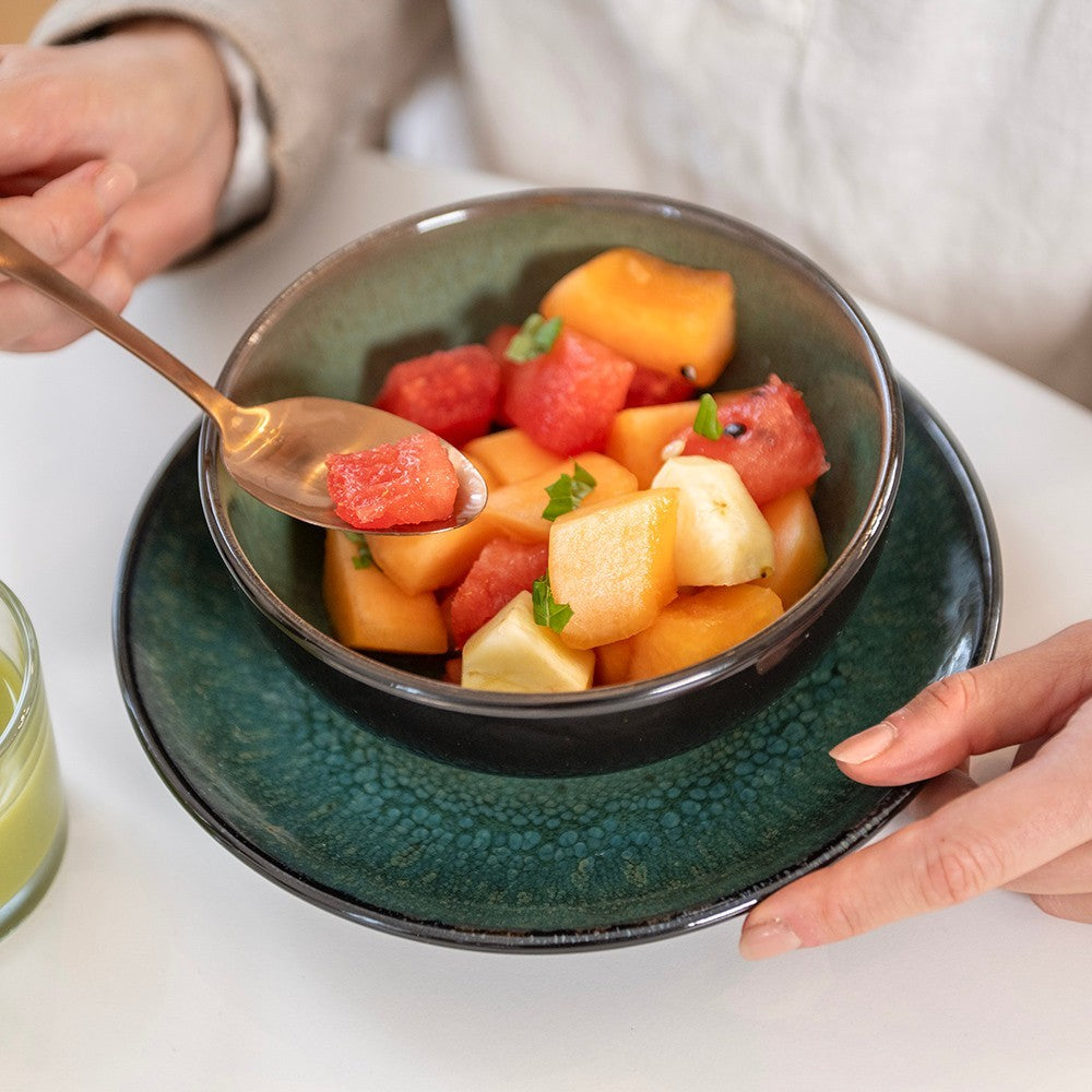 aelgmark black and green glazed ceramic serving bowl filled with fruit salad, perfect for breakfast or snacks.