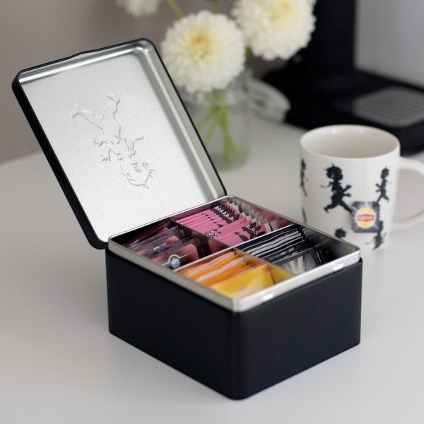 aelgmark black metal four-compartment tea bag storage tin with embossed boy design on lid.