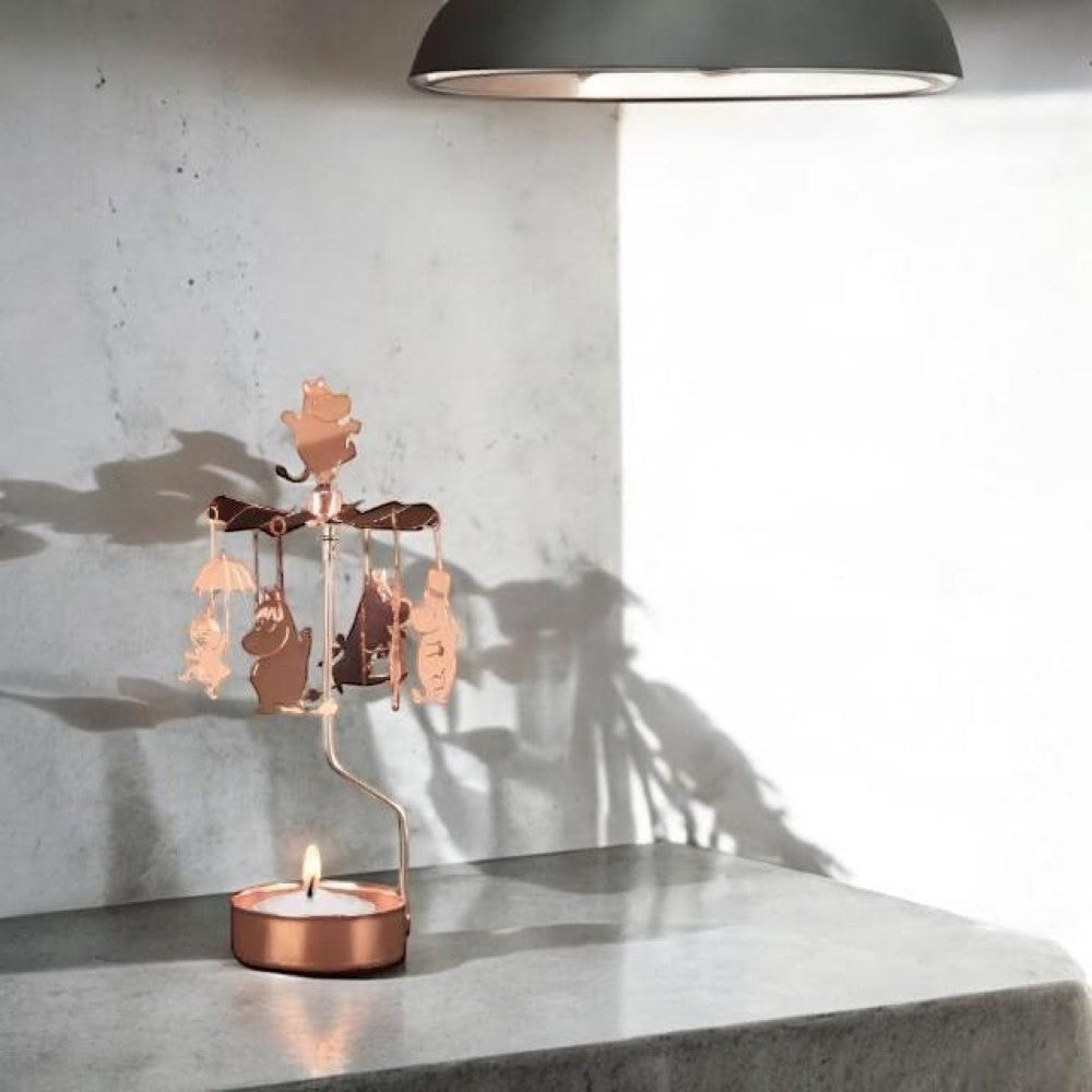 aelgmark copper Moomin family rotating candle holder with hanging charms and a lit tea light.