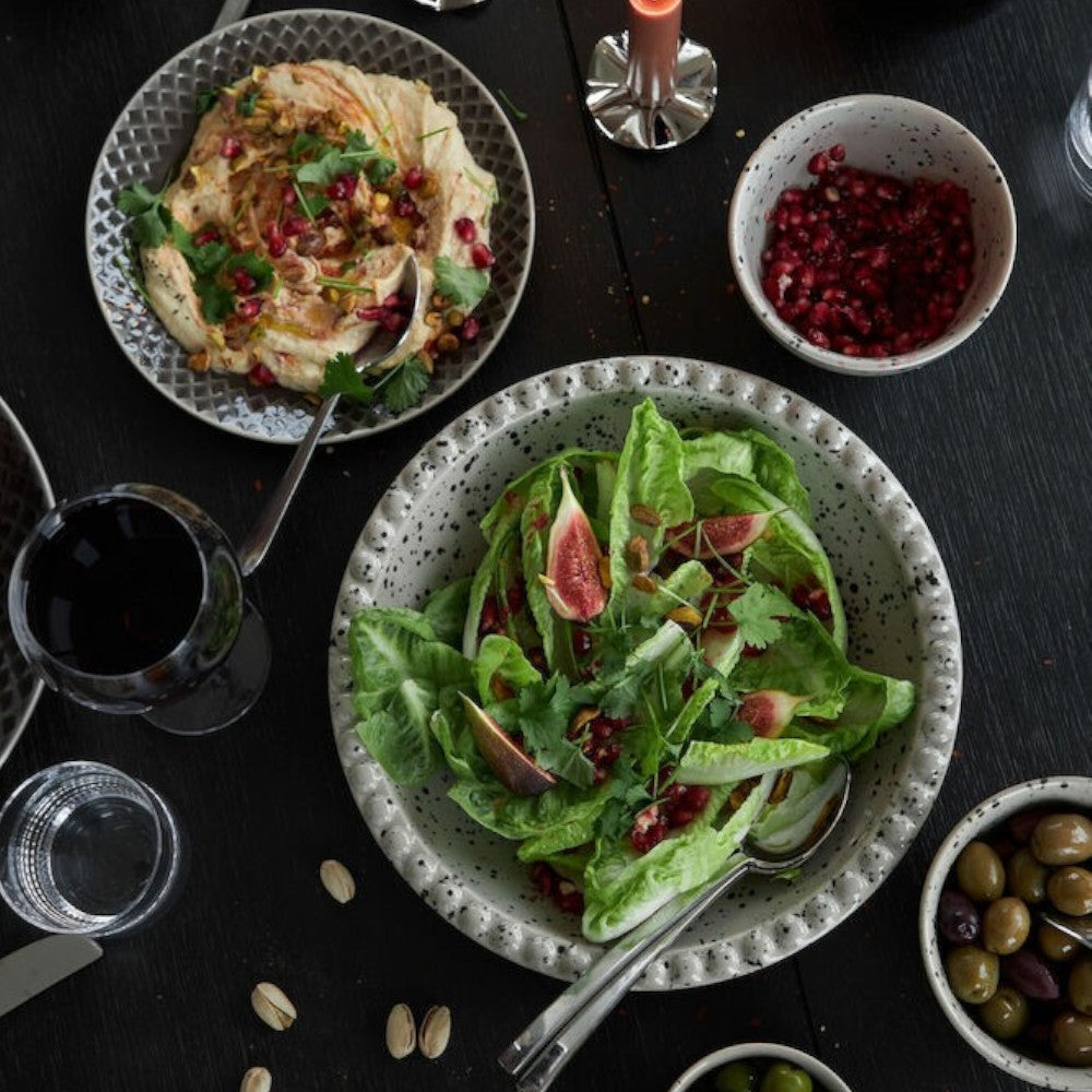 Aelgmark Ditte 26cm stoneware serving platter with a beige/grey speckled design and black splatter pattern, holding a salad.