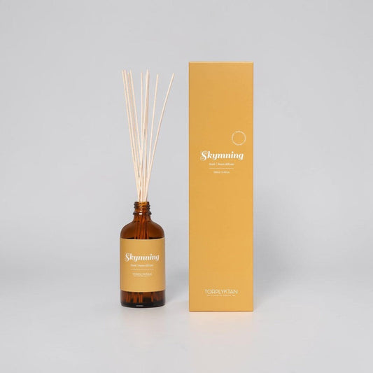 aelgmark Dusk room diffuser with almond, vanilla, and coconut scent. Amber glass bottle with reeds and yellow packaging.
