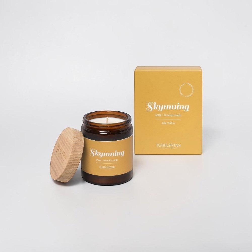 aelgmark Dusk scented candle in amber glass jar with wooden lid, notes of almond, vanilla, and coconut.