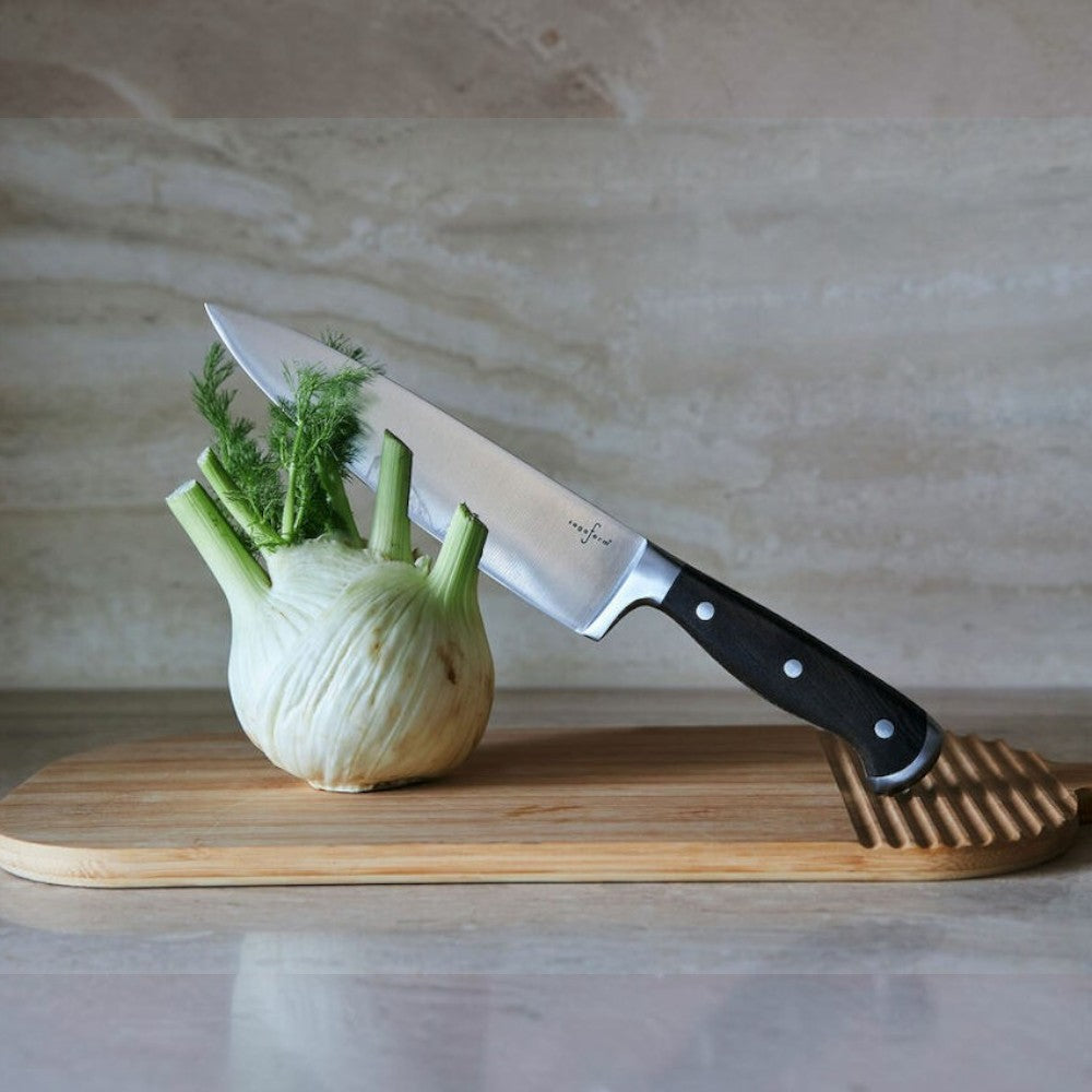 aelgmark Erik stainless steel chef's knife with dark wood handle and wave grip, ideal for chopping vegetables.