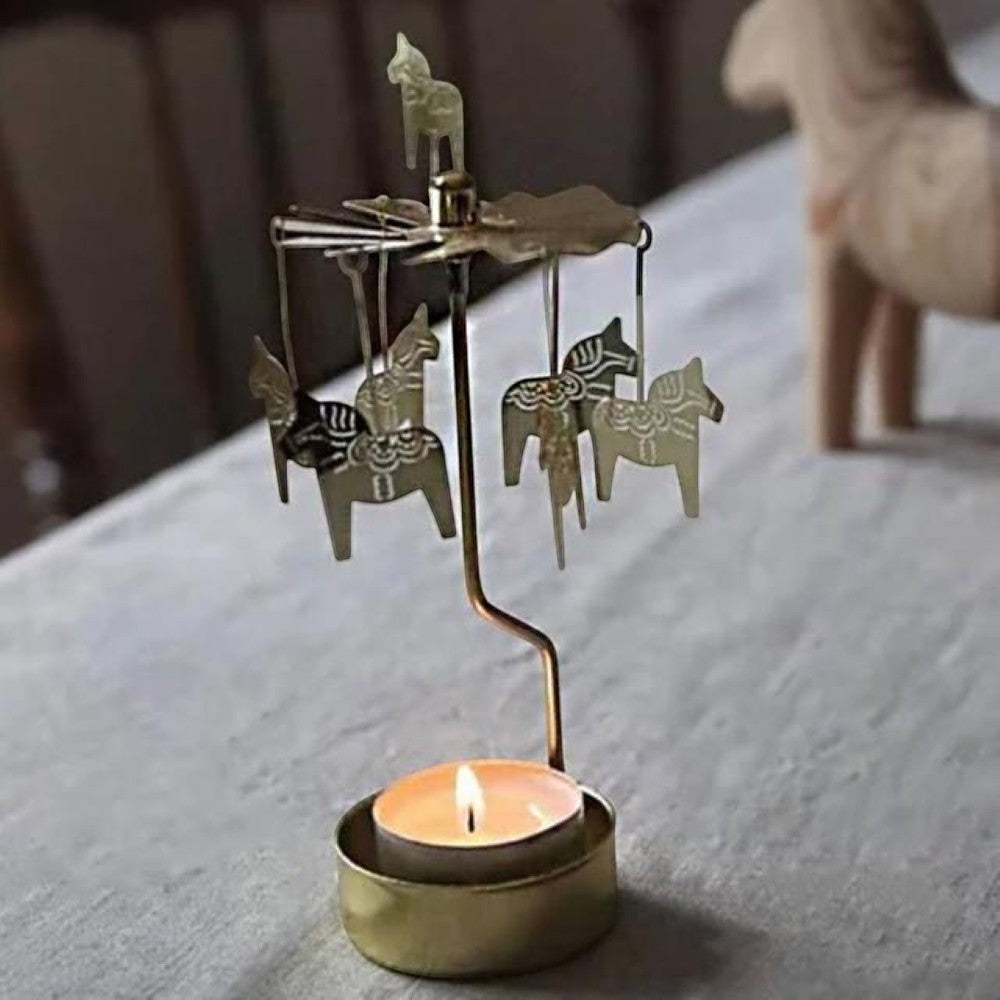 Aelgmark gold Dala horse rotating candle holder with a lit tea light, creating a carousel effect.