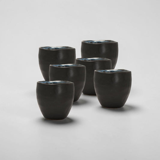 aelgmark Guilia black ceramic tea cup with blue glazed interior, 150ml, handmade with unique wavy rim.