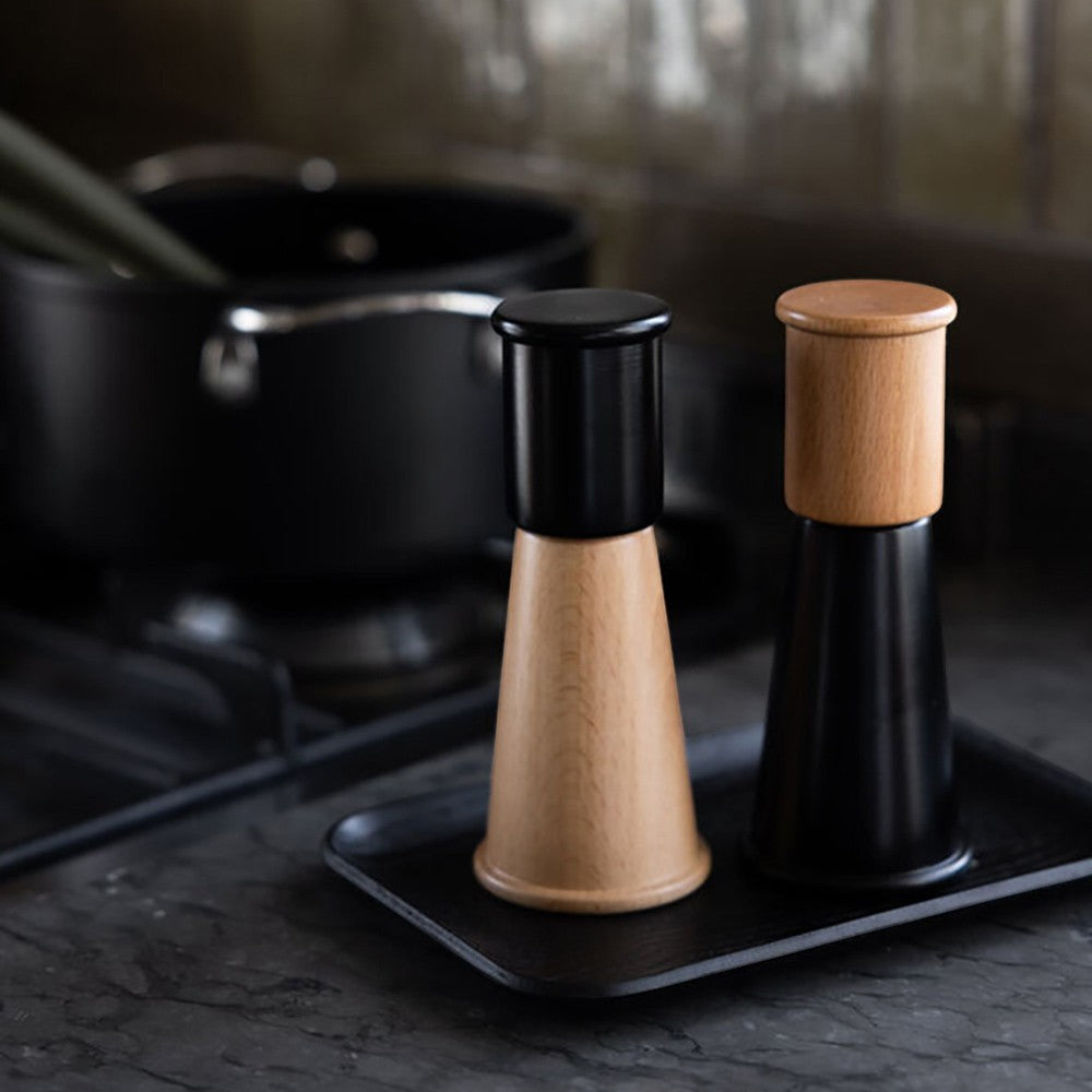 aelgmark北歐生活選物 Hanna matte black and natural wood salt and pepper grinders. Tapered wooden bases with black tops.