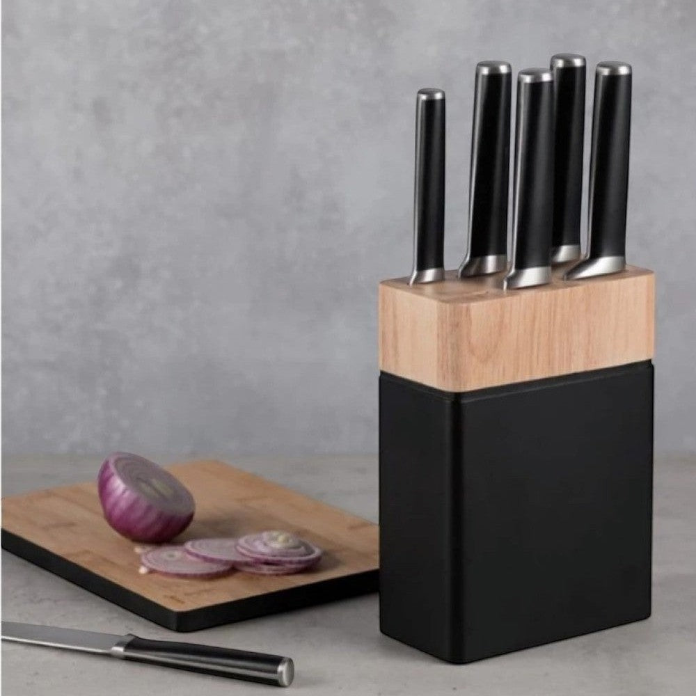 Aelgmark knife block with light wood top and black base, holding six kitchen knives. A cutting board with sliced red onion is nearby.