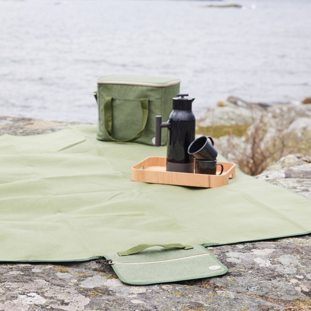 aelgmark City rPet picnic blanket in light green, waterproof backing, with zippered pocket and handle for easy carrying.