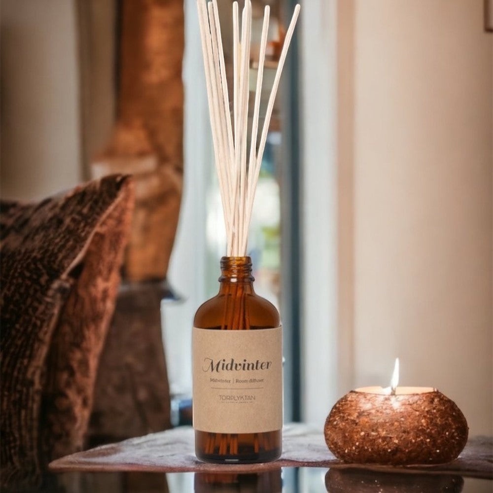 aelgmark Midvinter room diffuser with sandalwood and vanilla scent in amber glass bottle with reeds.