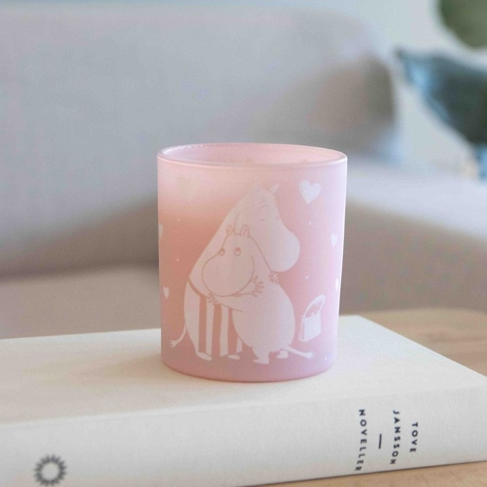 aelgmark Moomin hugging candle in pink frosted glass with white Moomin characters and hearts, fresh linen scent.