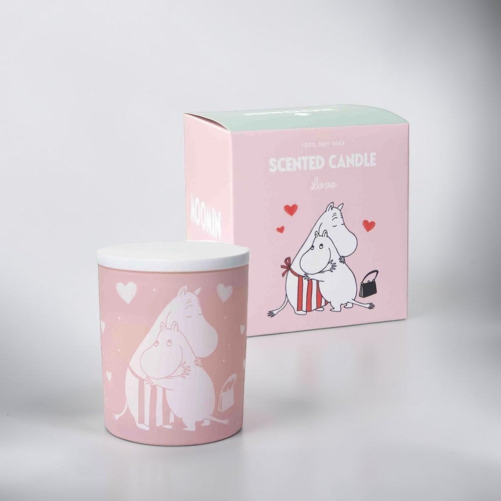aelgmark Moomin scented candle in pink with white Moomin characters hugging. Features a fresh linen scent.