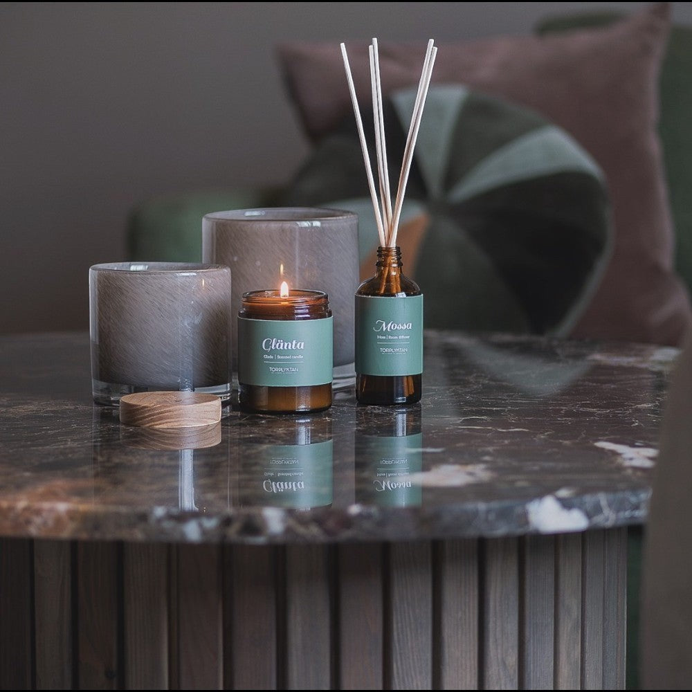aelgmark Mossa reed diffuser with pine, patchouli, and cedarwood scents in amber glass bottle with reeds.