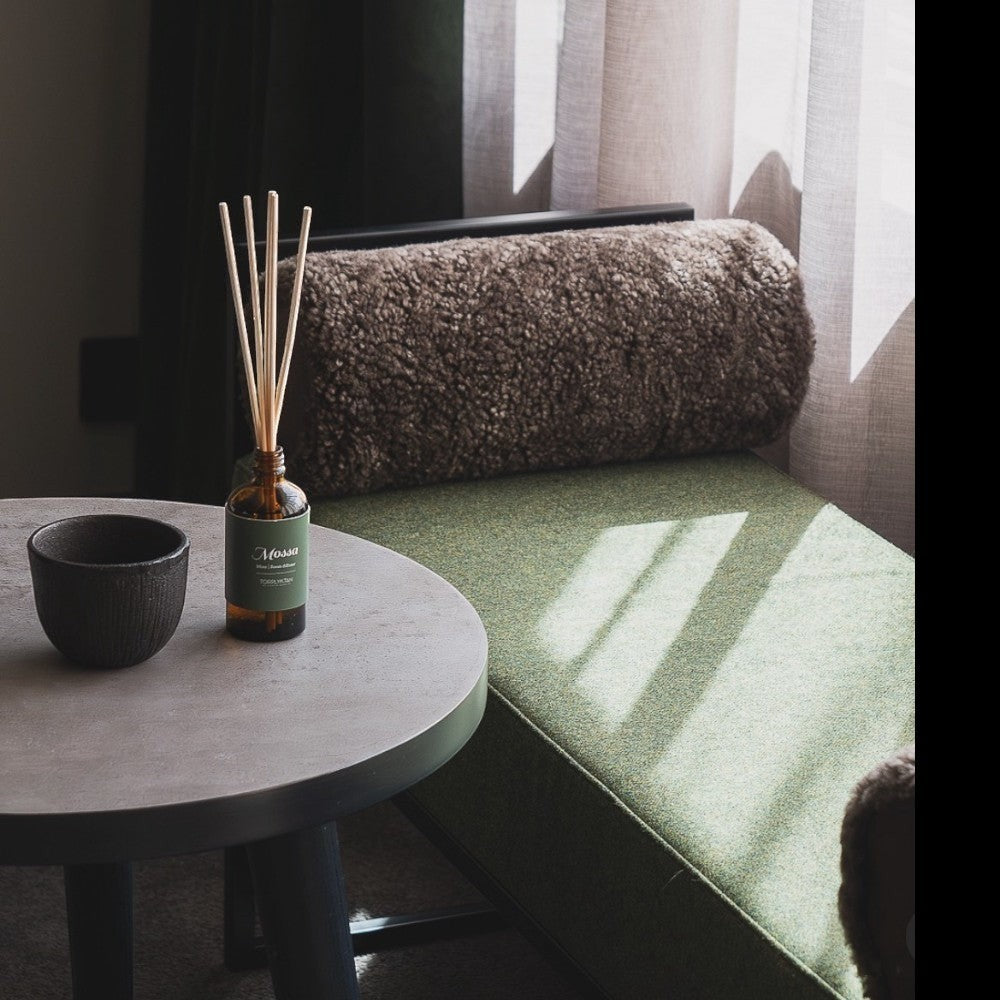 aelgmark Mossa reed diffuser with pine, patchouli, and cedarwood scents in a brown glass bottle with reeds.