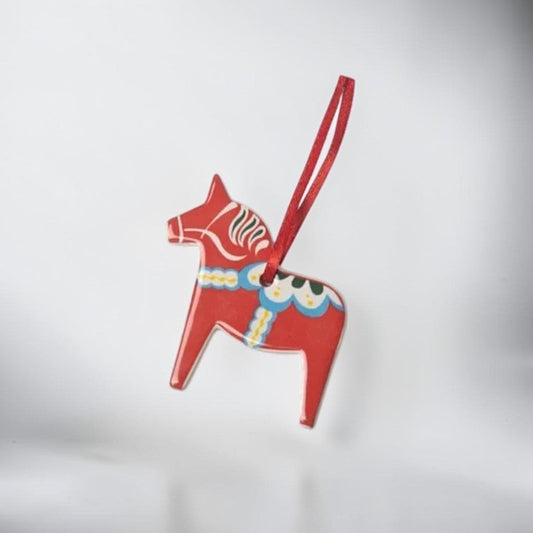 aelgmark red ceramic Dala horse ornament with white, blue, and yellow painted details and a red hanging ribbon.