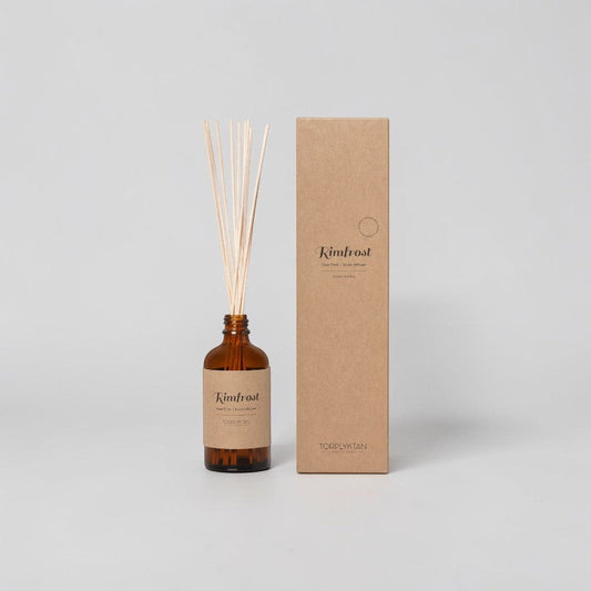aelgmark Rimfrost room diffuser with scent notes of cedar, iris, vanilla, sandalwood, and musk. Amber glass bottle with reeds.
