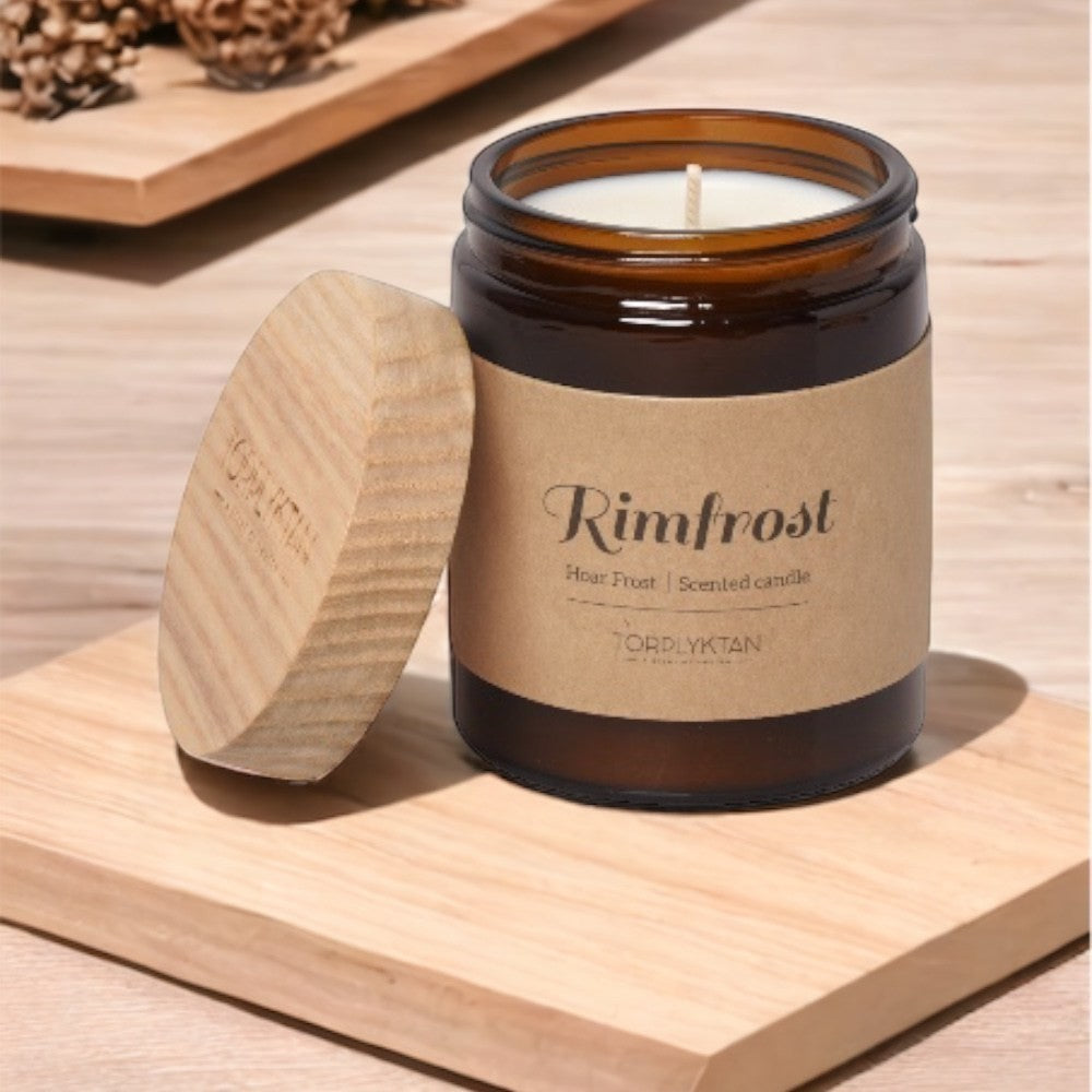 aelgmark Rimfrost Hoar Frost scented candle in amber glass jar with wooden lid, notes of cedar, iris, vanilla, sandalwood, musk.