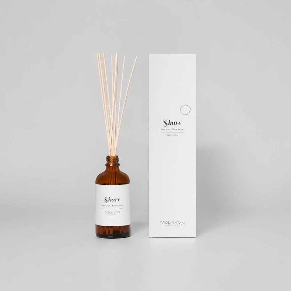 aelgmark Snow Crust room diffuser with cinnamon, mint, and bergamot notes in amber glass bottle with reeds.