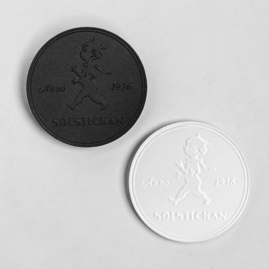 aelgmark SOLSTICKAN cast iron trivet in black and white, featuring the iconic 1936 boy graphic.