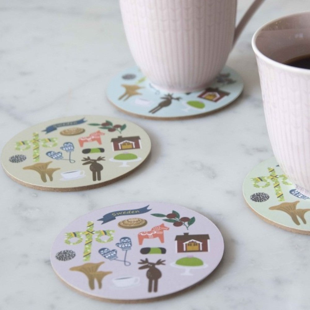 aelgmark set of 4 wooden coasters with Swedish folk art motifs like Dala horses, moose, houses, and mushrooms in pastel colors.