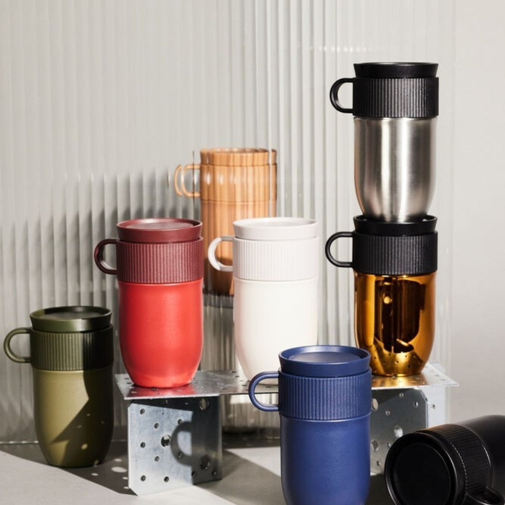 aelgmark Ted travel mug in red, white, navy, olive green, stainless steel, gold, and bamboo. Features ribbed grip and handle.