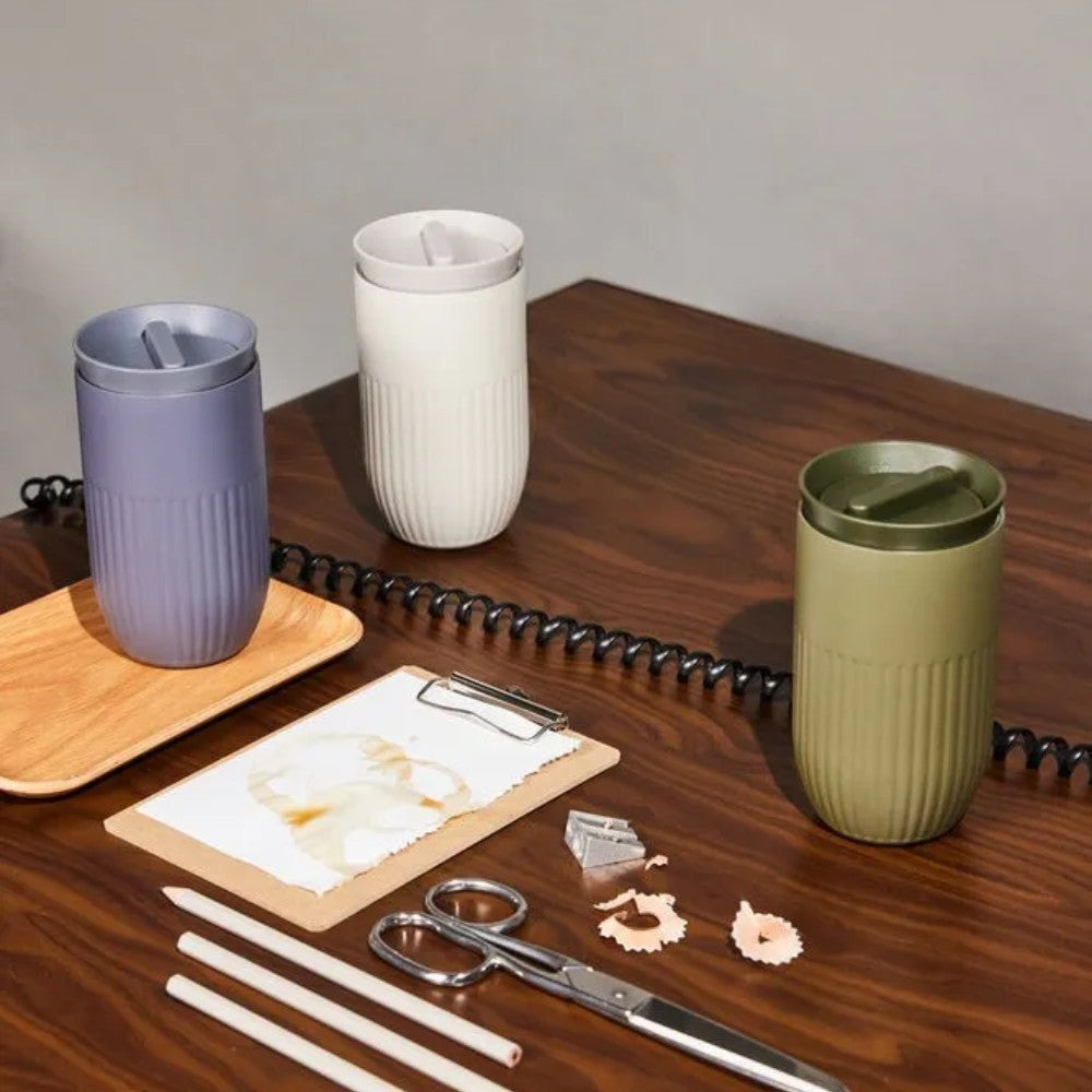 aelgmark Tova travel mug in lavender, cream, and olive green. Features ribbed design, 360-degree drinking lid, and vacuum insulation.