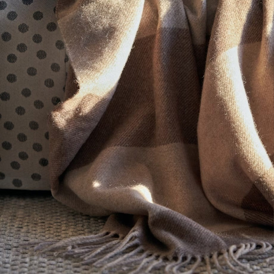 aelgmark Ulle merino wool throw blanket in beige and brown plaid with fringe detail.