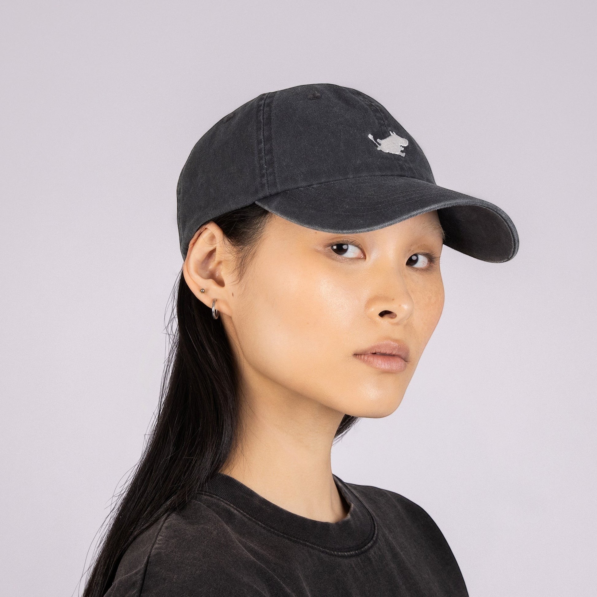 aelgmark 北歐生活選物黑色丹寧姆明老帽，正面有白色姆明刺繡，模特兒配戴展示經典北歐休閒風格